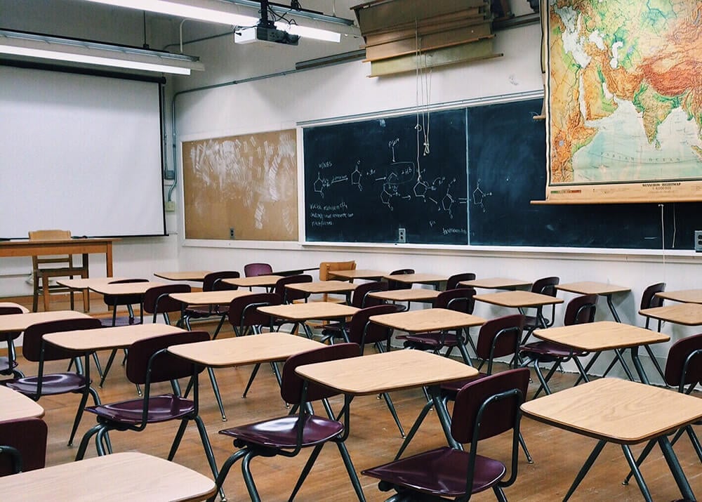 Empty classroom with projector screen and chalkboard